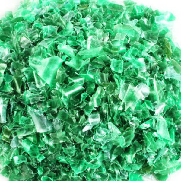 Small pieces of cut green plastic bottles on white paper